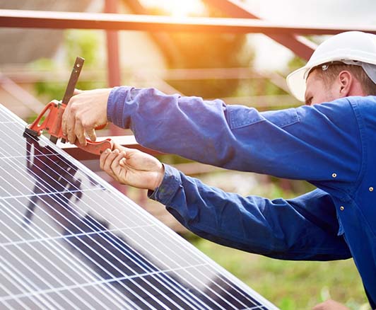 Technician performing solar panel maintenance